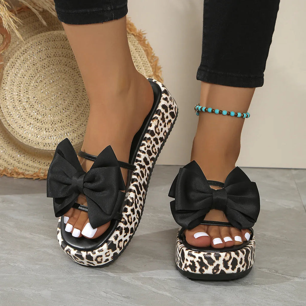 Leopard print women's beach slippers with thick sole and round toe in black colour.