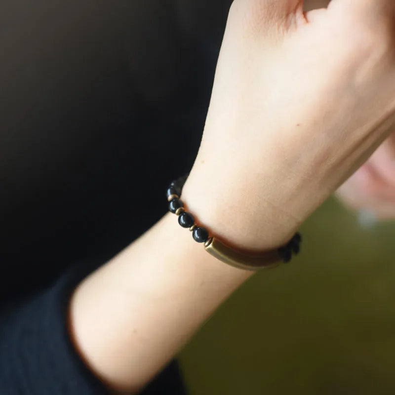 Layered multi-strand ethnic bracelet with natural stone beads and brass detailing on wrist