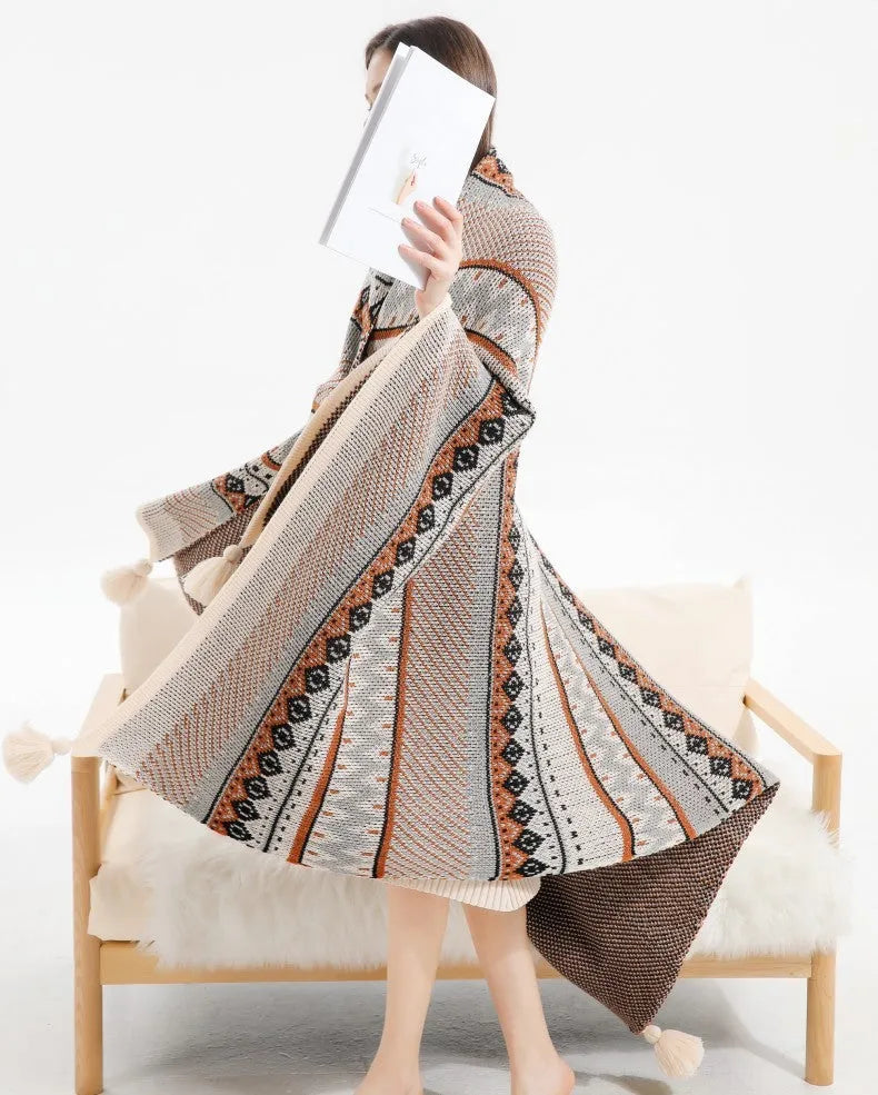 Acrylic sofa blanket with tassel fringe in neutral beige tone on grey sofa
