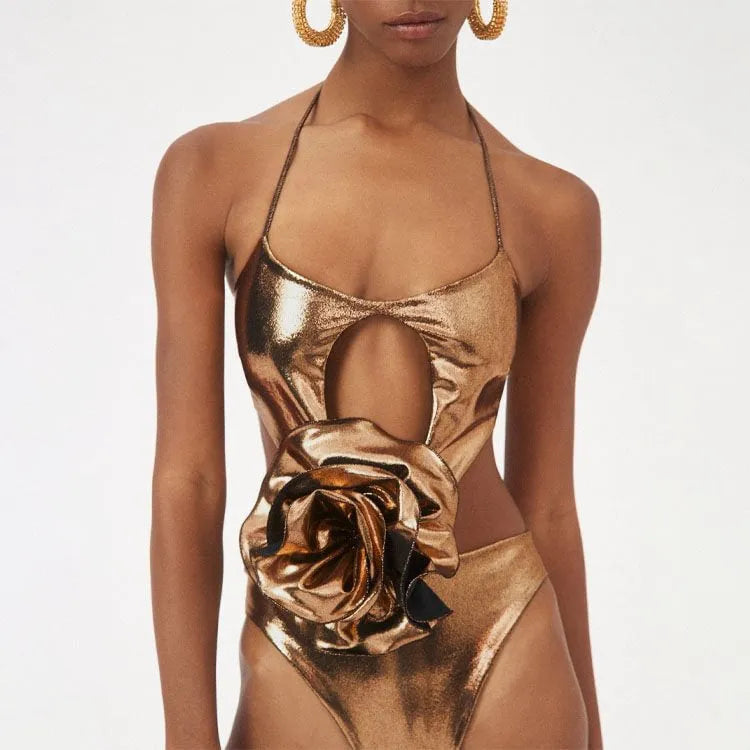 Gold coloured handmade halter neck one-piece swimsuit with hollow-out design on a mannequin.