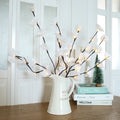 Pink LED phalaenopsis orchid branch decorative light on a table, 65cm long with warm white lights.