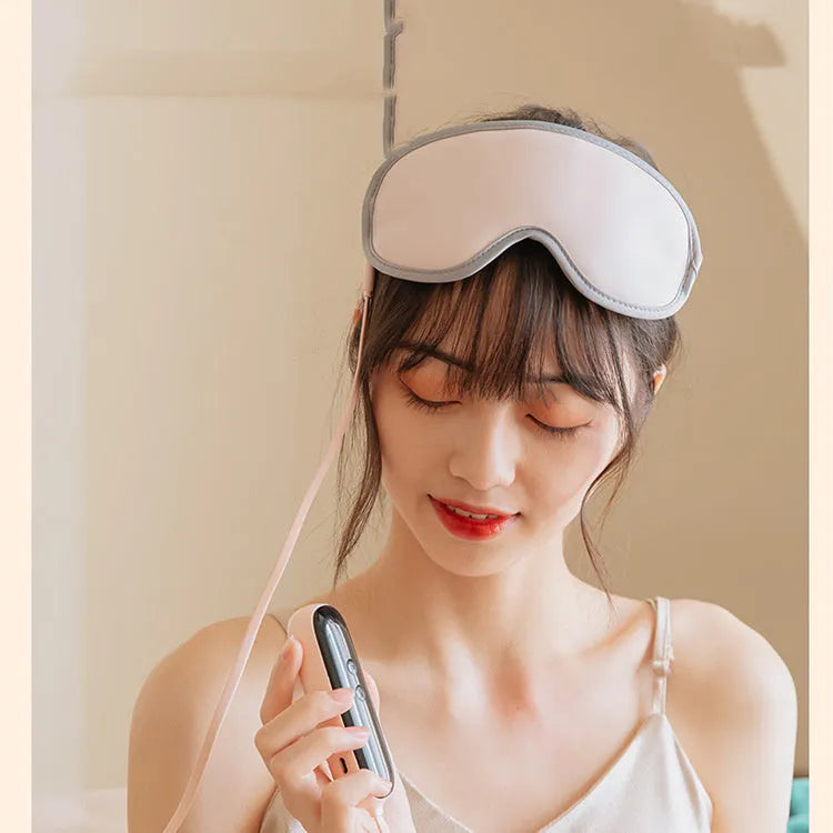 Green portable eye SPA mask with USB cable on a grey background