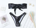 Black bikini print one-piece swimsuit with a split tube top design on a mannequin.