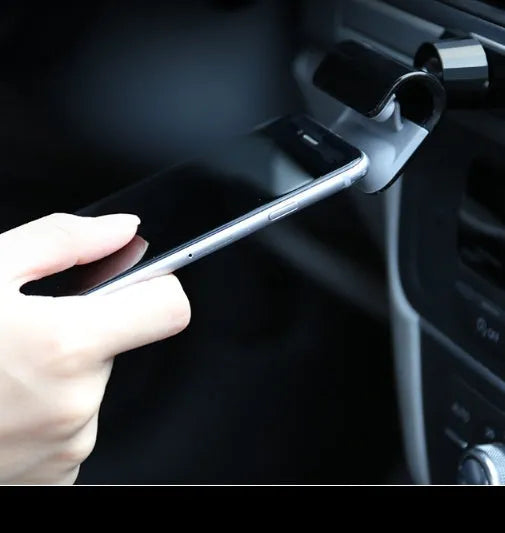 Black universal car phone holder with 360-degree rotating head on dashboard