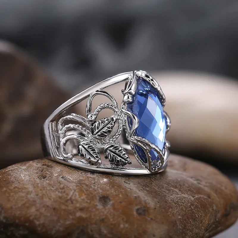 Blue horse eye-shaped crystal ring for women on a hand, showing geometric alloy design.