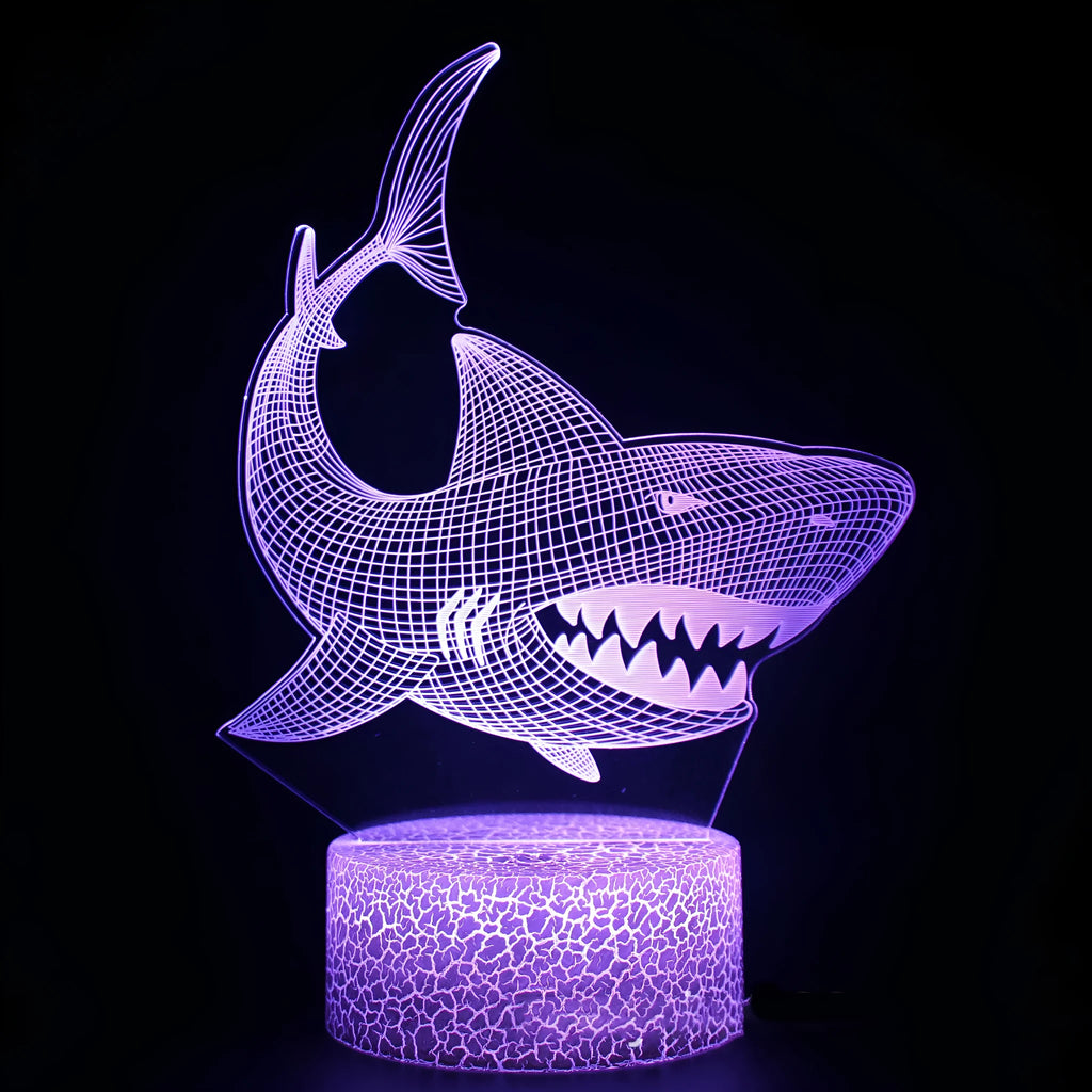 Shark-shaped 3D LED table lamp with touch base and remote control showing colour-changing illumination.