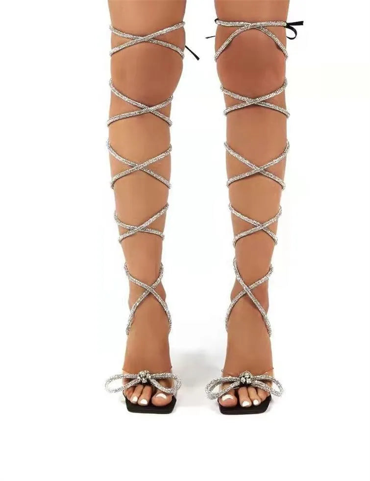 Plus size women's black strappy sandals with rhinestone decorations on Roman-style straps and a square toe.