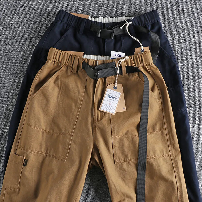 Men's khaki cotton work trousers with an N I buckle belt on a mid-rise waist.