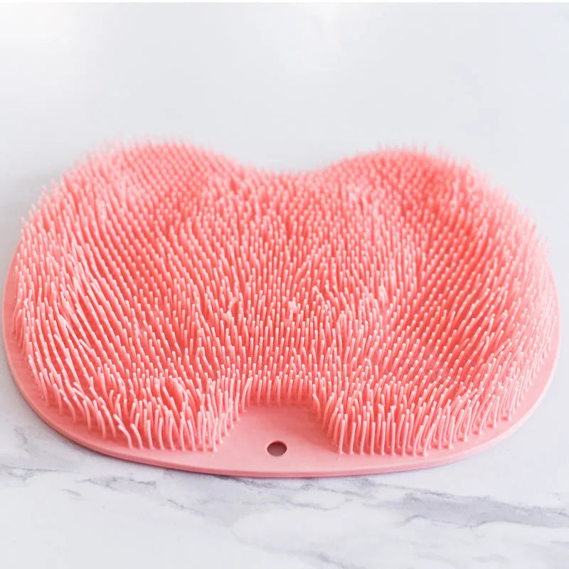 Orange silicone bath brush with suction cups on back and hundreds of small bristles for cleaning feet and back.