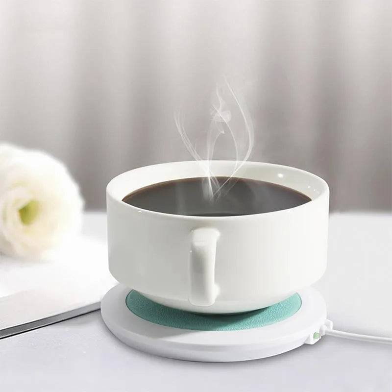 USB-powered insulated heating coaster in black, blue, or orange on a desk.