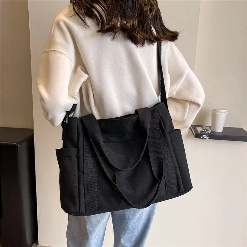 Large canvas shoulder bag for women in solid colour with external pocket and internal phone compartment