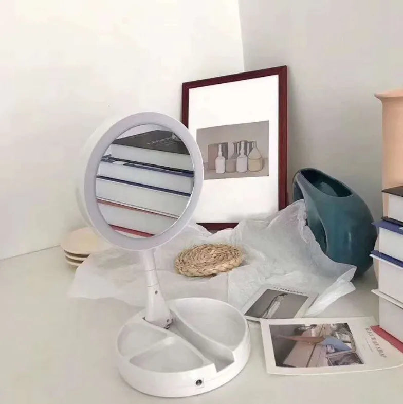 White foldable double-sided LED vanity mirror with built-in storage compartments and USB cable.