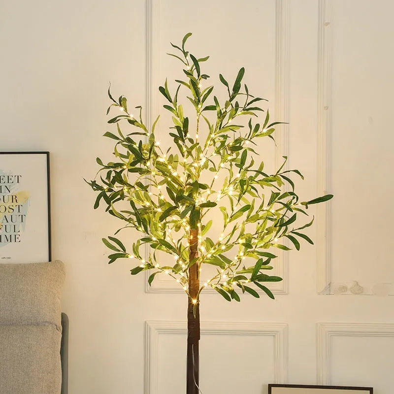 Tall 1.8m artificial olive tree lamp with warm white LEDs illuminating simulation leaves in a courtyard setting.