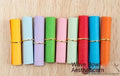 Assortment of colourful mini paper scrolls with metal eyelets for drift bottle messages and crafts.