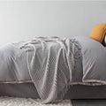 Small polyester nap blanket in dark grey, khaki, or light grey colours showing 127x170cm dimensions