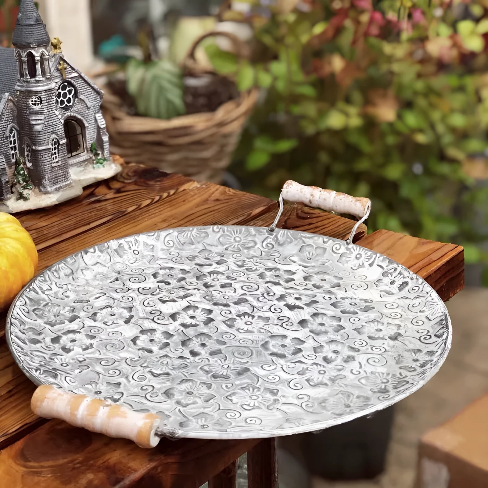 Round wrought iron storage tray in two sizes on a wooden surface.