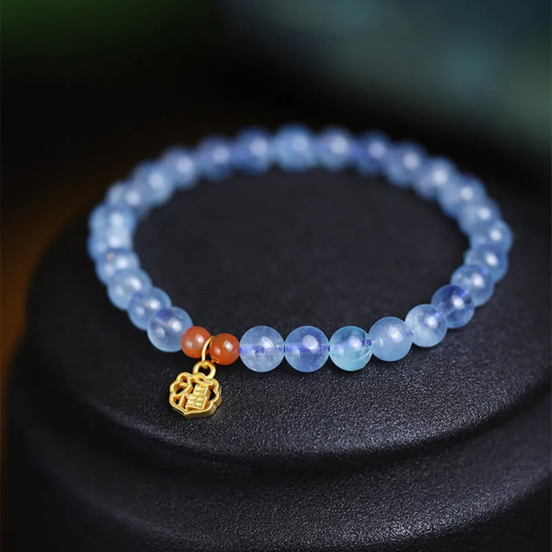 Women's crystal bracelet with ice translucent aquamarine 8mm round beads and sequin detailing on a white background.