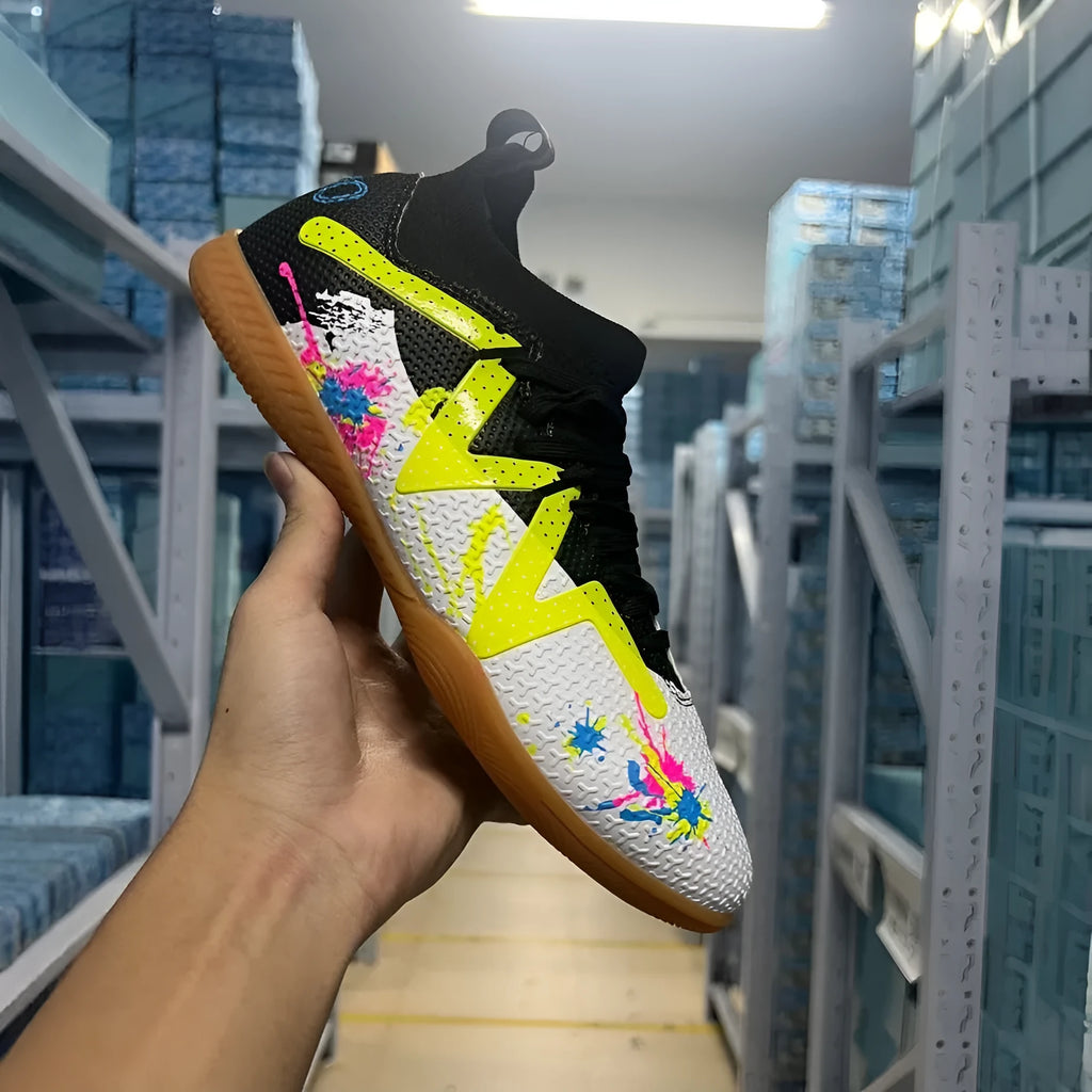 Low-top soccer shoes in black and yellow colour with a PVC upper and rubber studded outsole.