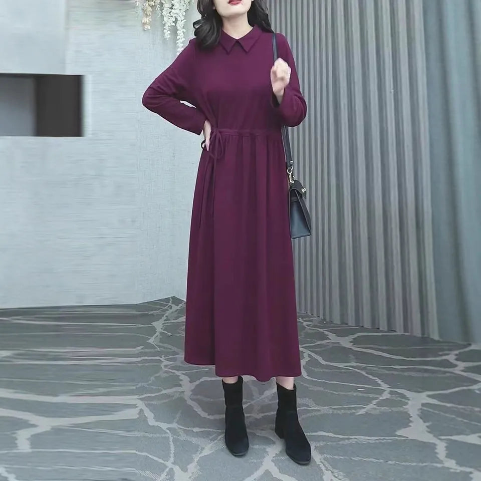 Purplish red plus size long sleeve long skirt dress for women on a hanger.