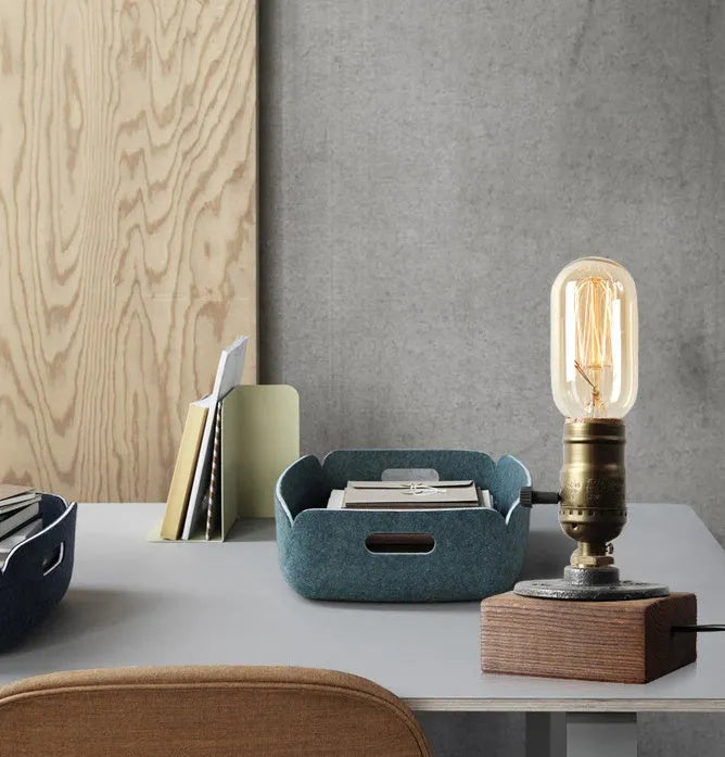 Compact wooden and iron water pipe table lamp on a table surface