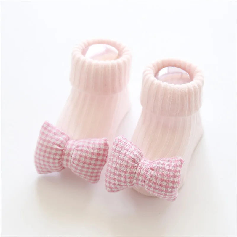 Cotton baby floor socks in a selection of colours and patterns like panda, lion, and bows, shown in sizes for infants.