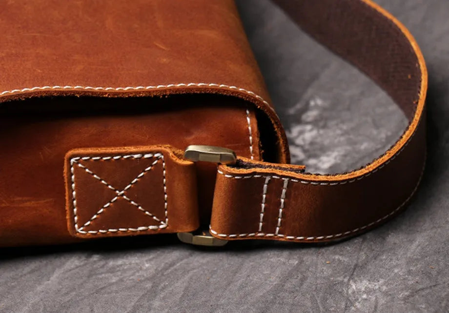 Vintage brown leather mens messenger bag with a flap opening and adjustable shoulder strap.