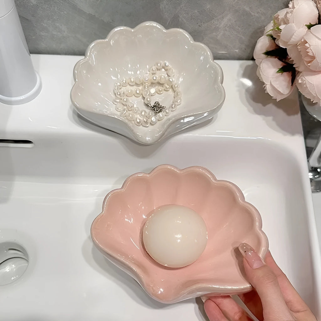 White plastic shell-shaped soap dish for bathroom countertop or wall.