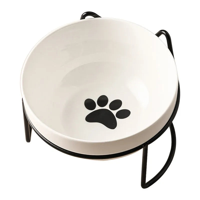 White ceramic cat bowl with cat paw print design on a black iron stand, shown as a pet feeding station.