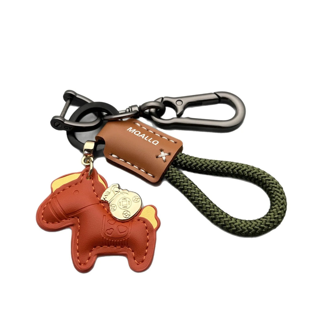 Handmade brown cowhide leather key ring with a gold-toned zinc alloy pony buckle and a green plaited flannelette rope.