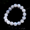 Natural blue polished moonstone round bead bracelet with adjustable clasp on a wrist.