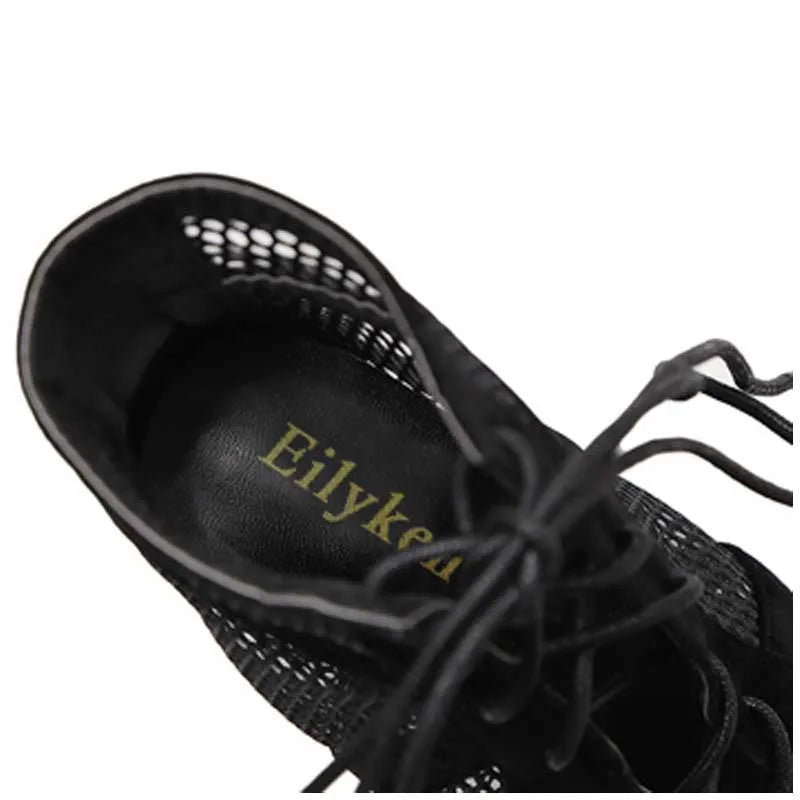 Black suede women's lace-up high heel shoes with a tall heel on a white background.