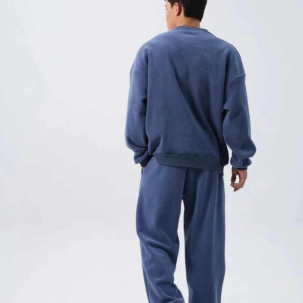 Men's black polar fleece sports suit with crew neck coat and padded trousers on a hanger