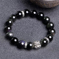 Natural obsidian bracelet with silver 999 clasp in 10mm or 12mm size on a wrist.