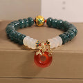 Women's blue water jade and red agate bracelet with peace buckle closure and rhinestone details