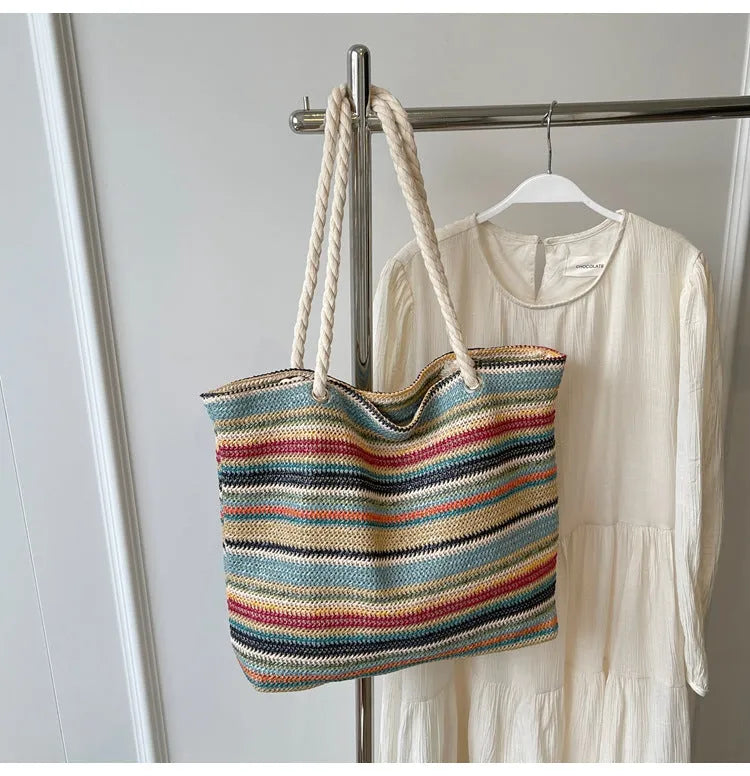 Blue woven straw and nylon shoulder bag with a large main compartment and zippered closure.