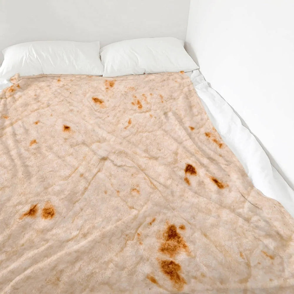 Round coral-coloured flannel burrito blanket with a delicious food print, folded to show soft texture.