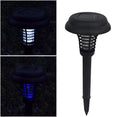 Black solar powered insect killing mosquito lawn lamp with white and purple light LEDs in a garden setting.