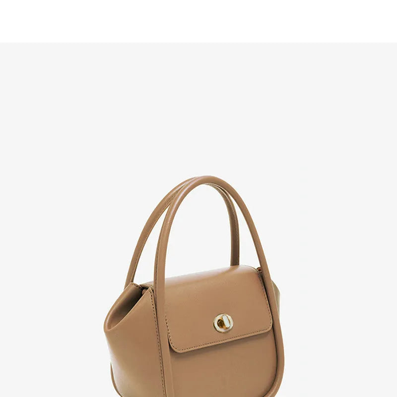 A wing-shaped women's leather tote bag with a buckle latch, shown in blue with a cross-body strap.