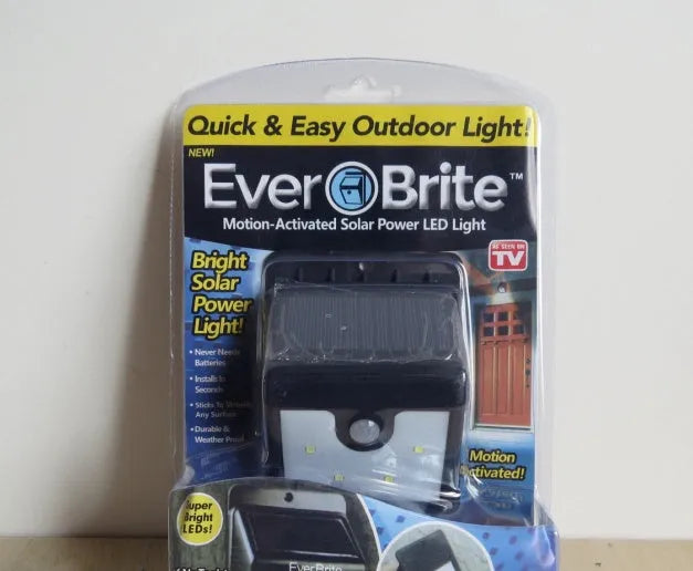 Set of four black solar-powered motion sensor LED lights for outdoor use.