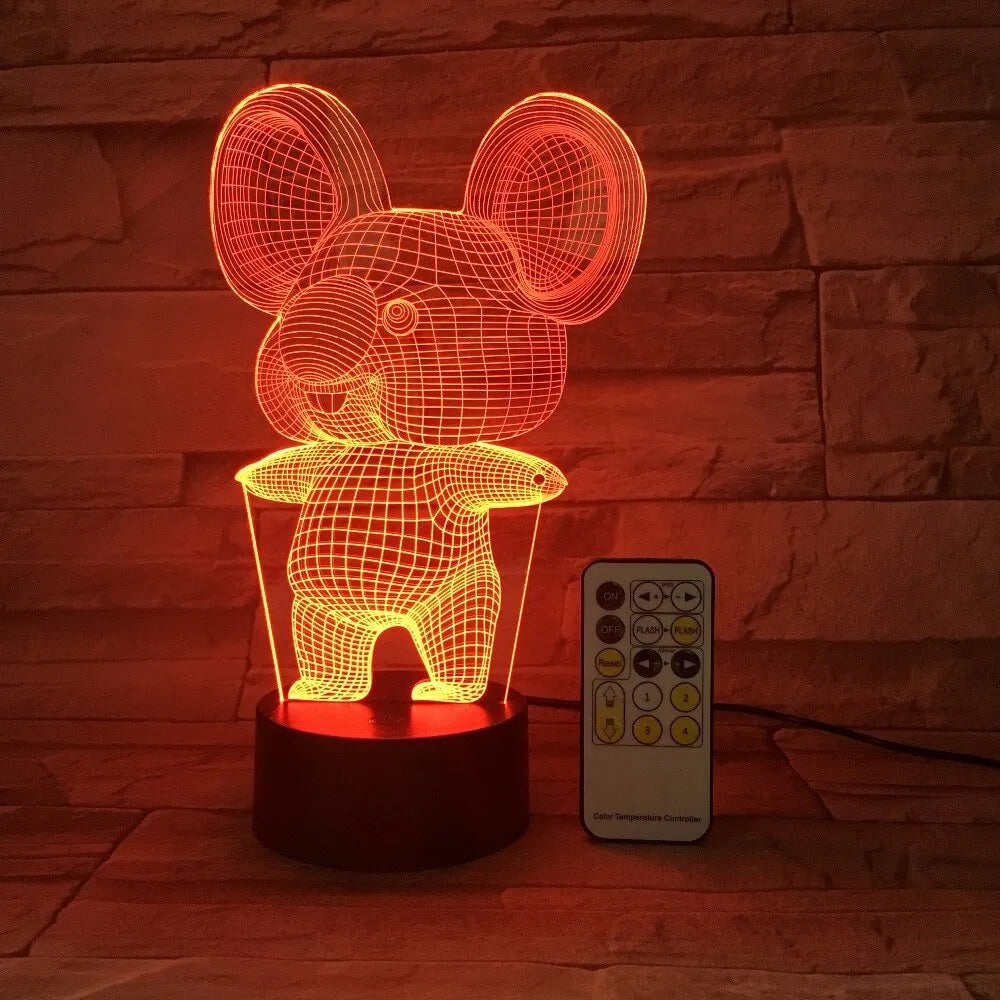 Koala-shaped LED night light with remote control on a bedside table, showing multiple colour options.