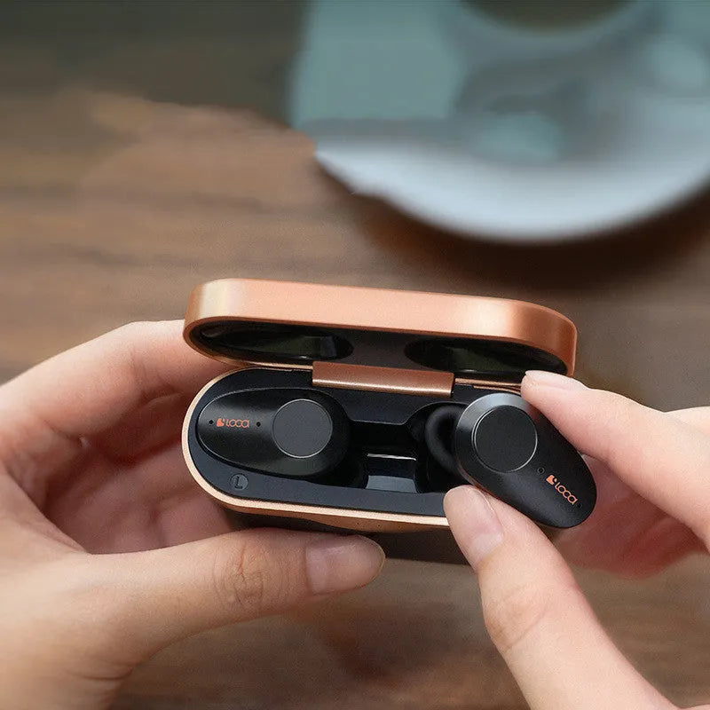 Black wireless Bluetooth headset with charging stand on a table.