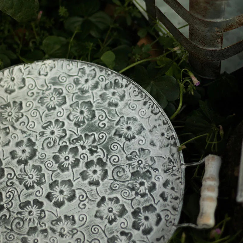Round wrought iron storage tray in two sizes on a wooden surface.