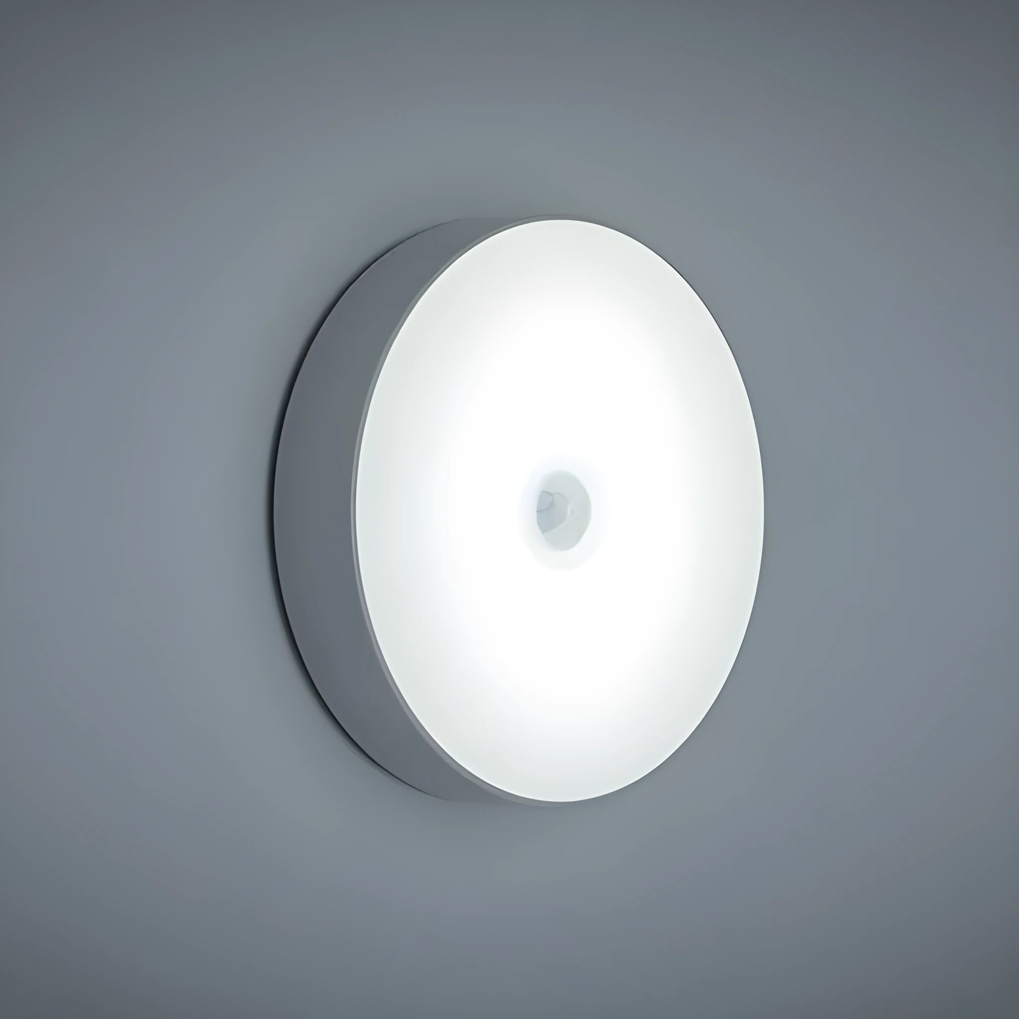 White circular motion sensor night light with USB charging port and adhesive backing