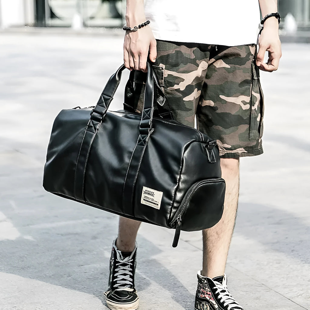 Large black PU leather sports training bag showing multiple internal organiser pockets and a single shoulder strap.