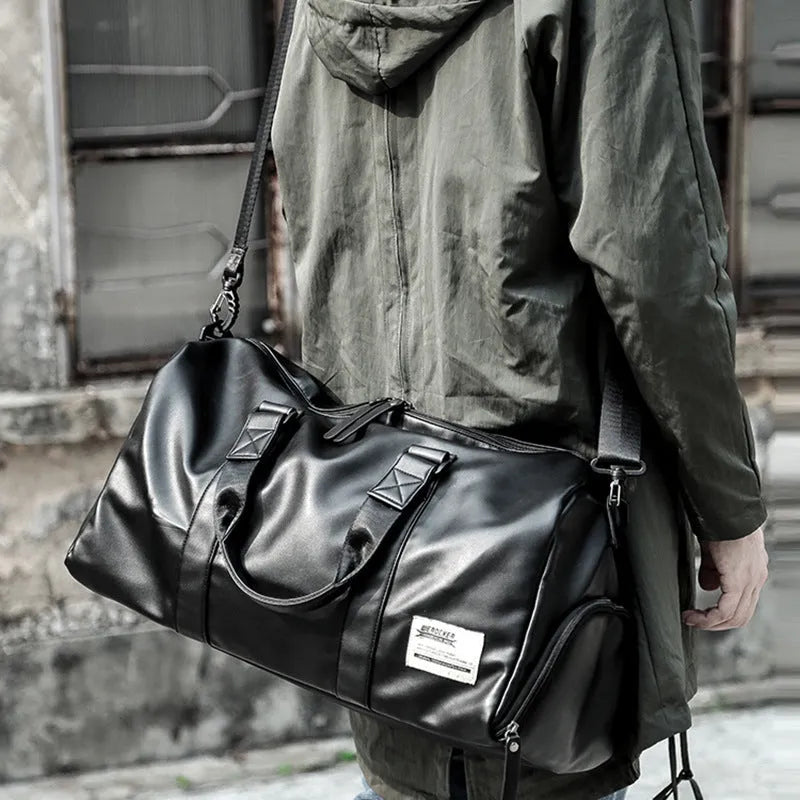 Large black PU leather sports training bag showing multiple internal organiser pockets and a single shoulder strap.