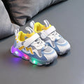 Children's bright sports sneakers with mesh panels and Velcro straps in black, pink, and grey.