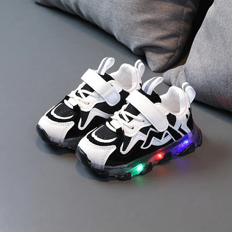 Children's bright sports sneakers with mesh panels and Velcro straps in black, pink, and grey.