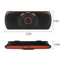 Orange Bluetooth car hands-free speaker unit shown mounted on a car sun visor.