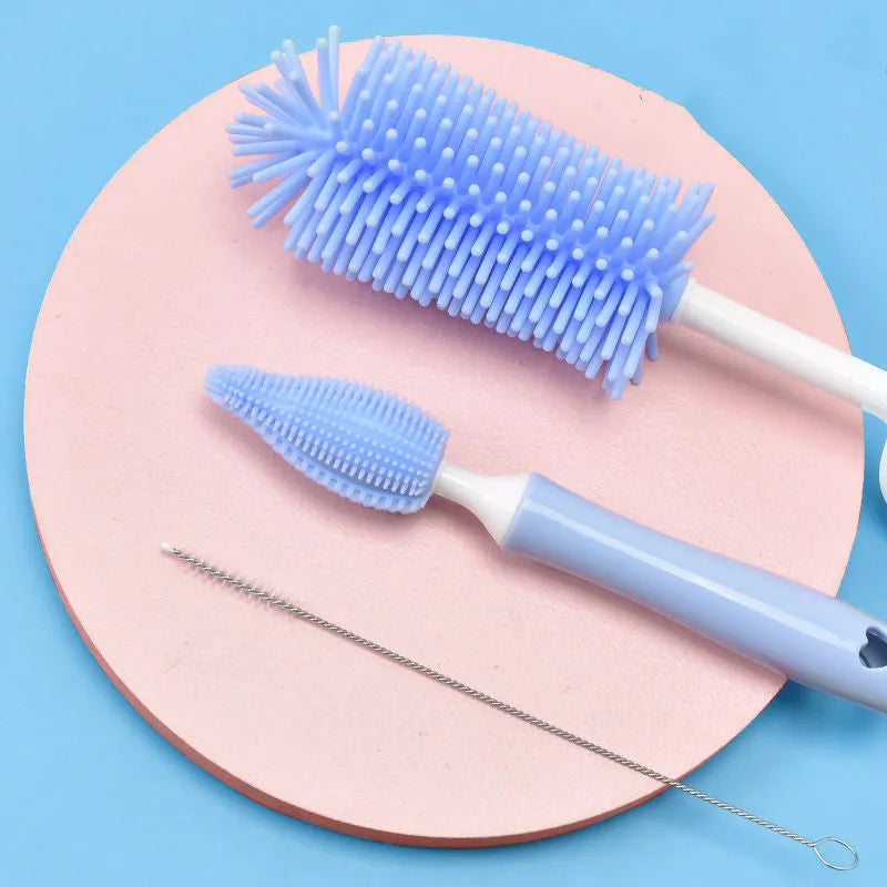 Pink, blue, and yellow silicone baby bottle brush sets with a straw cleaning brush.