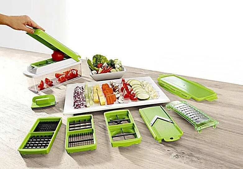 Green manual vegetable chopper with stainless steel blades and multiple cutting accessories on kitchen counter